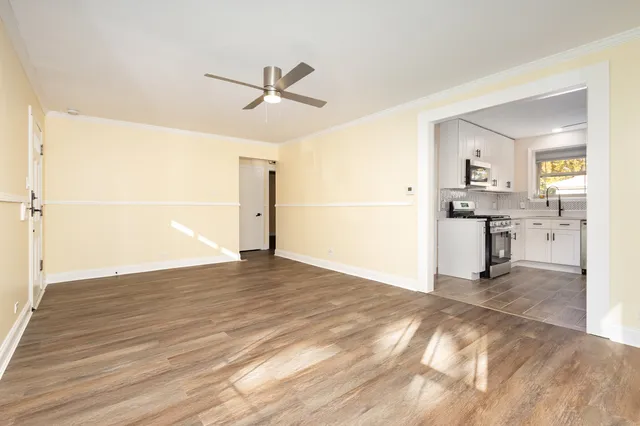 a view of a kitchen with wooden floor and a ceiling fan