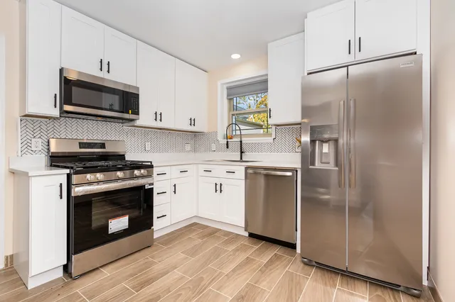 a kitchen with stainless steel appliances a refrigerator sink and microwave