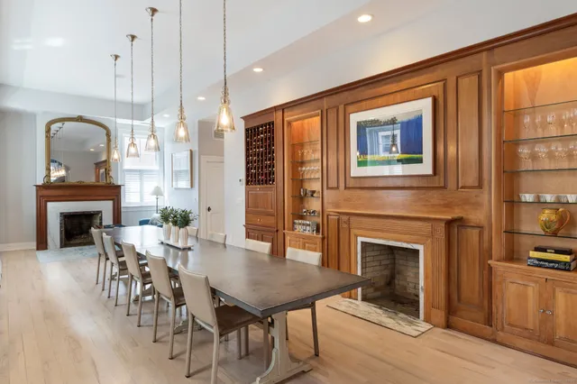 a dining room with furniture a fireplace and wooden floor