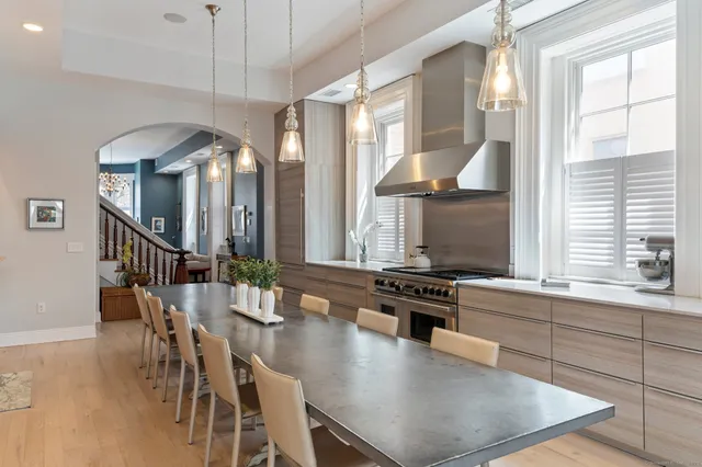 a kitchen with stainless steel appliances granite countertop a stove a sink and a dining table with chairs