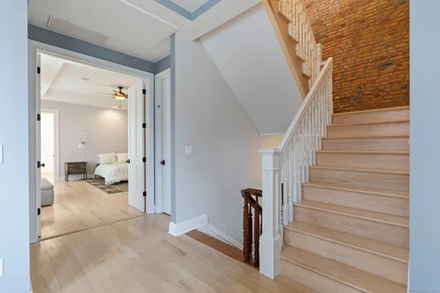 a view of a hallway with wooden floor and stairs