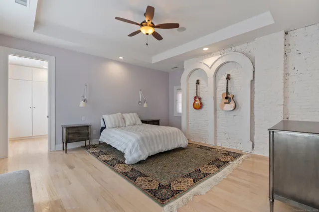a bedroom with a large bed and wooden floor