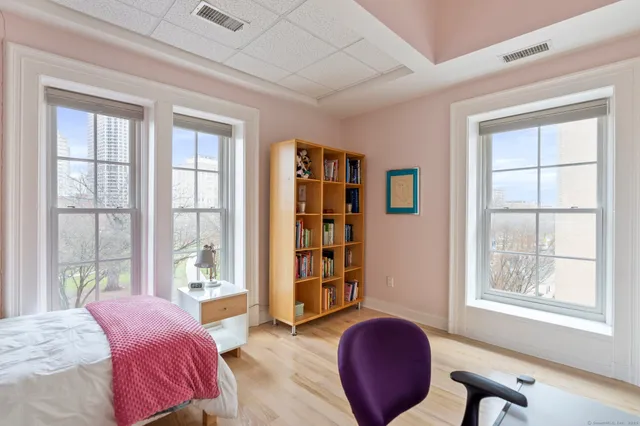a bedroom with a bed and large window