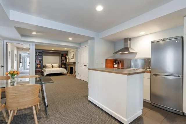 a living room with furniture and a refrigerator