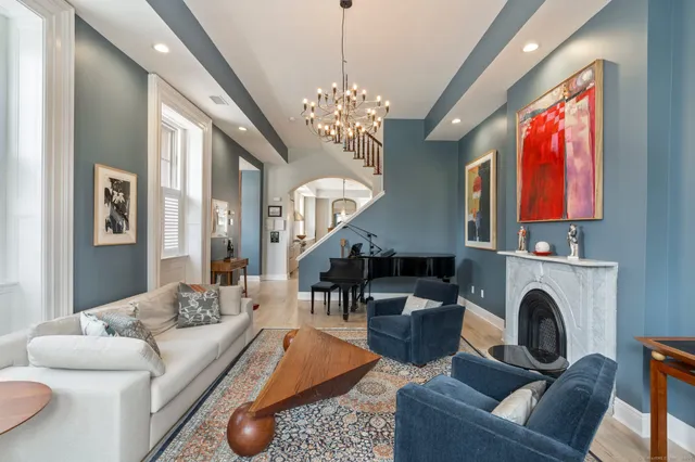 a living room with furniture a fireplace and a chandelier