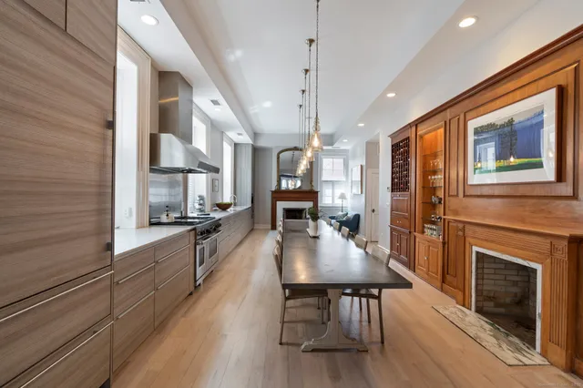 a large kitchen with a table chairs stainless steel appliances and cabinets