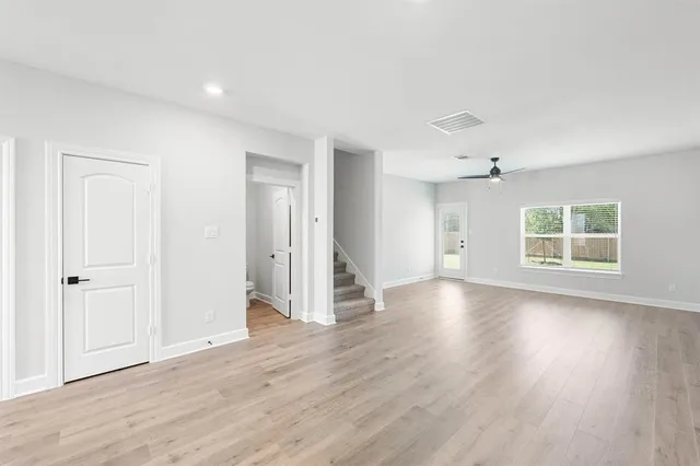 an empty room with wooden floor and a window