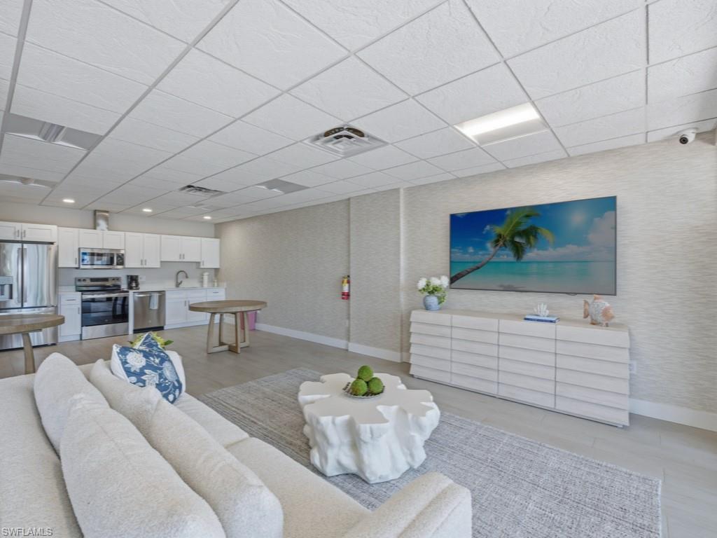 3 Bluebill Avenue, Unit 206 Naples, FL 34108 - Photo 16 of 19 a living room with furniture and a flat screen tv