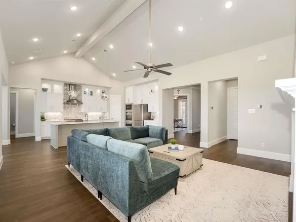 a living room with furniture and view of kitchen