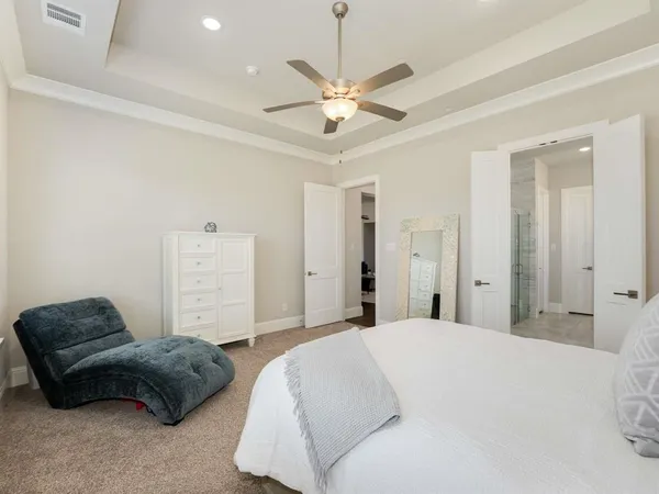 a bedroom with a bed couches and ceiling fan