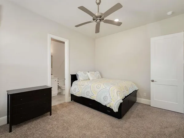 a spacious bedroom with a bed and a ceiling fan