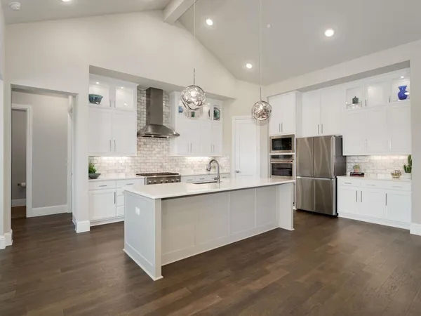 a kitchen with stainless steel appliances white cabinets and wooden floor