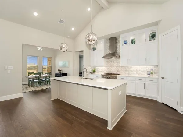 a kitchen with a sink cabinets and wooden floor