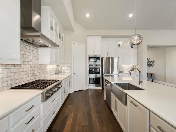 a kitchen with kitchen island stainless steel appliances a sink stove and cabinets