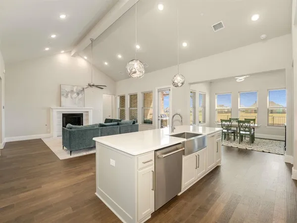 a large white kitchen with a large island in the center
