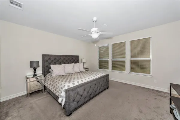 a large bed sitting in a bedroom next to a large window