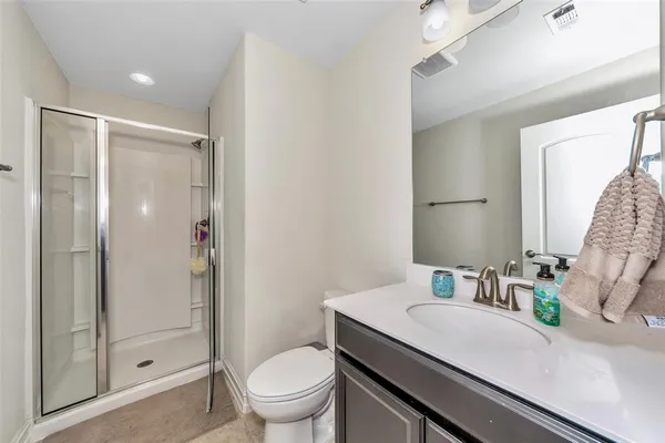 a bathroom with a granite countertop sink toilet and shower