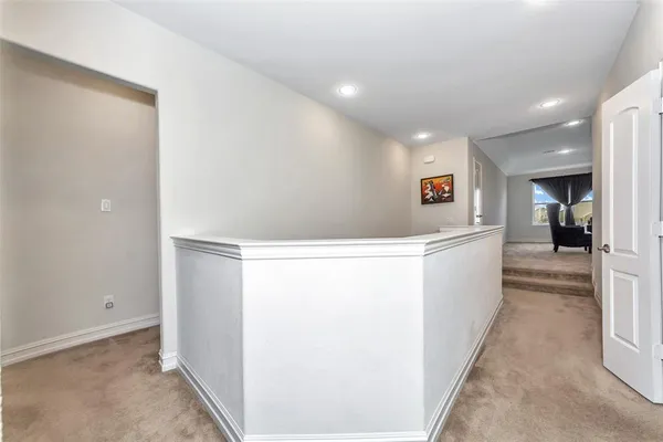 a view of hallway with furniture and a refrigerator