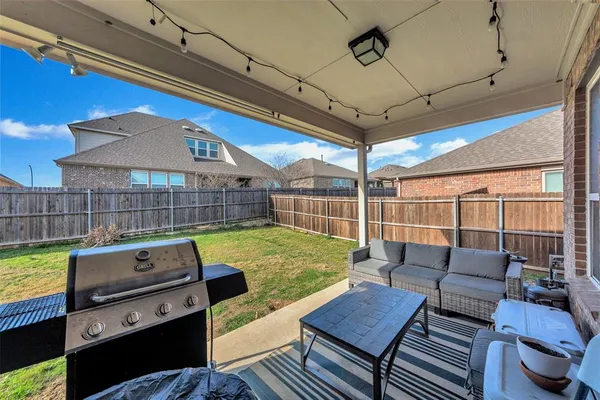 a view of a patio with couches chairs and wooden floor