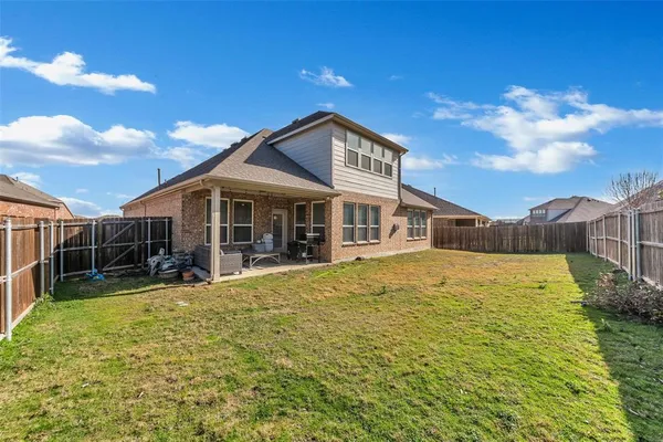 a view of a house with floor to ceiling windows and a yard