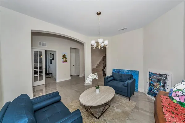 a living room with furniture a dining table and a chandelier