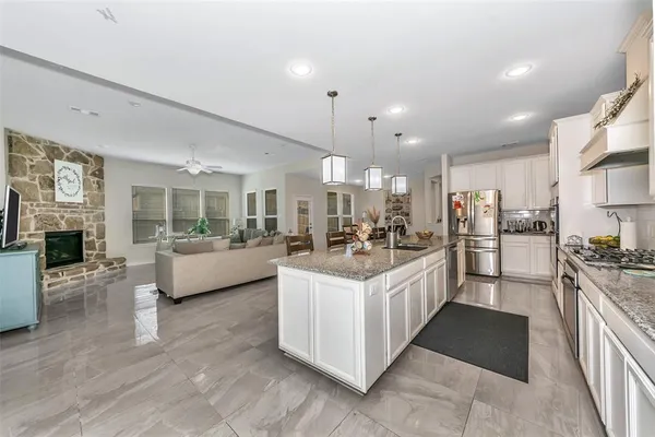 a large white kitchen with a large window and stainless steel appliances