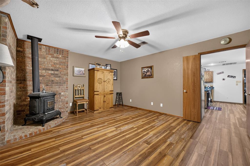 10964 River Ranch Road Kemp, TX 75143 - Photo 11 of 40 Brick accent wall with a cast iron wood-burning stove
