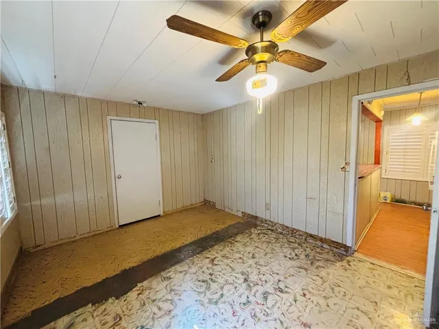 a view of a livingroom with a chandelier fan and wooden floor