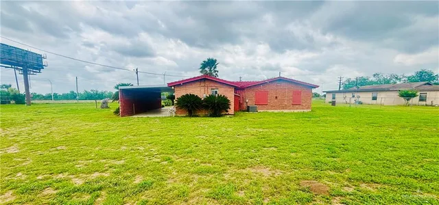 a view of a house with a big yard and a large tree