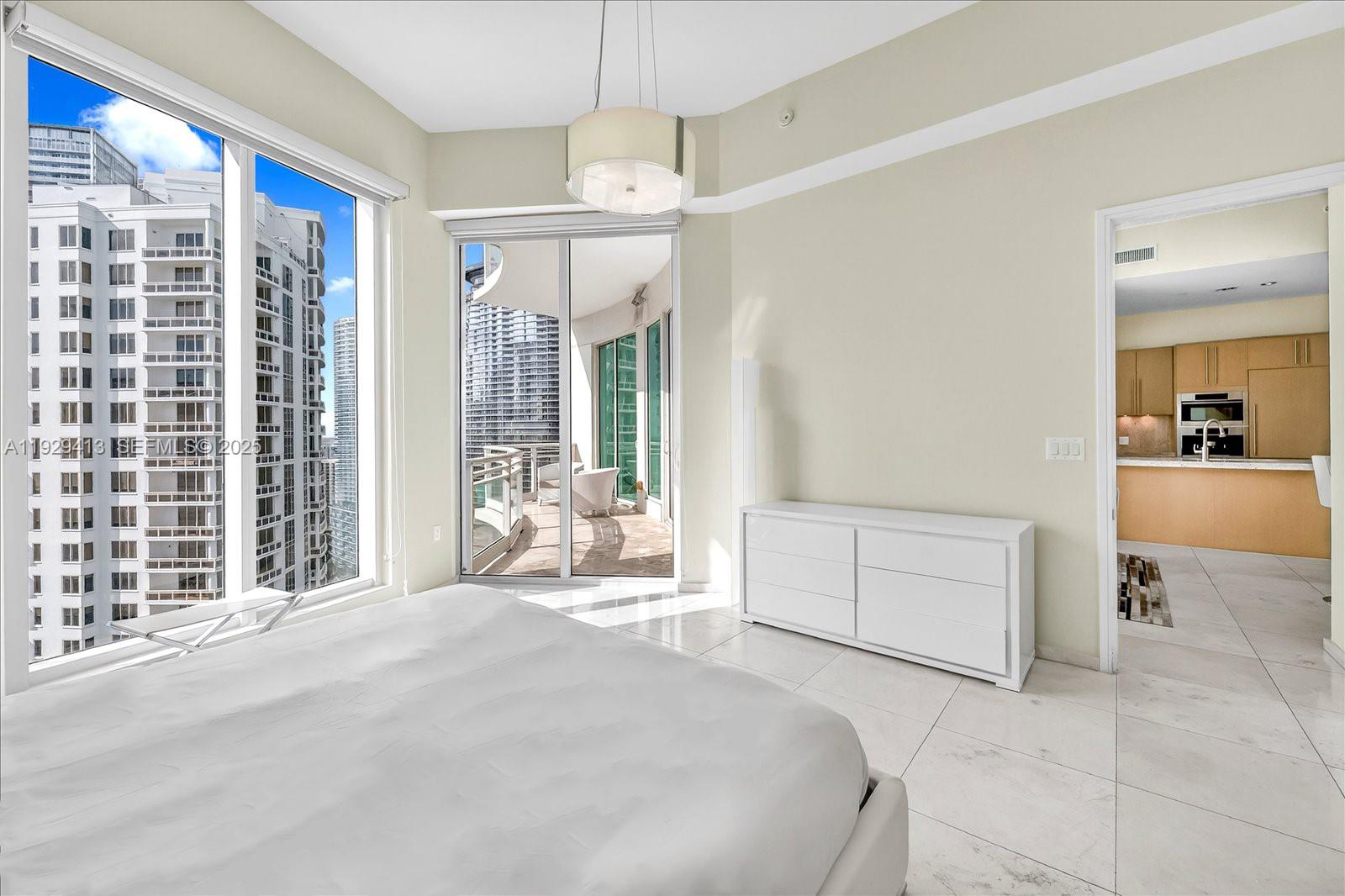 900 Brickell Key Boulevard, Unit 2605 Miami, FL 33131 - Photo 12 of 43 a bedroom with a large bed and a chandelier
