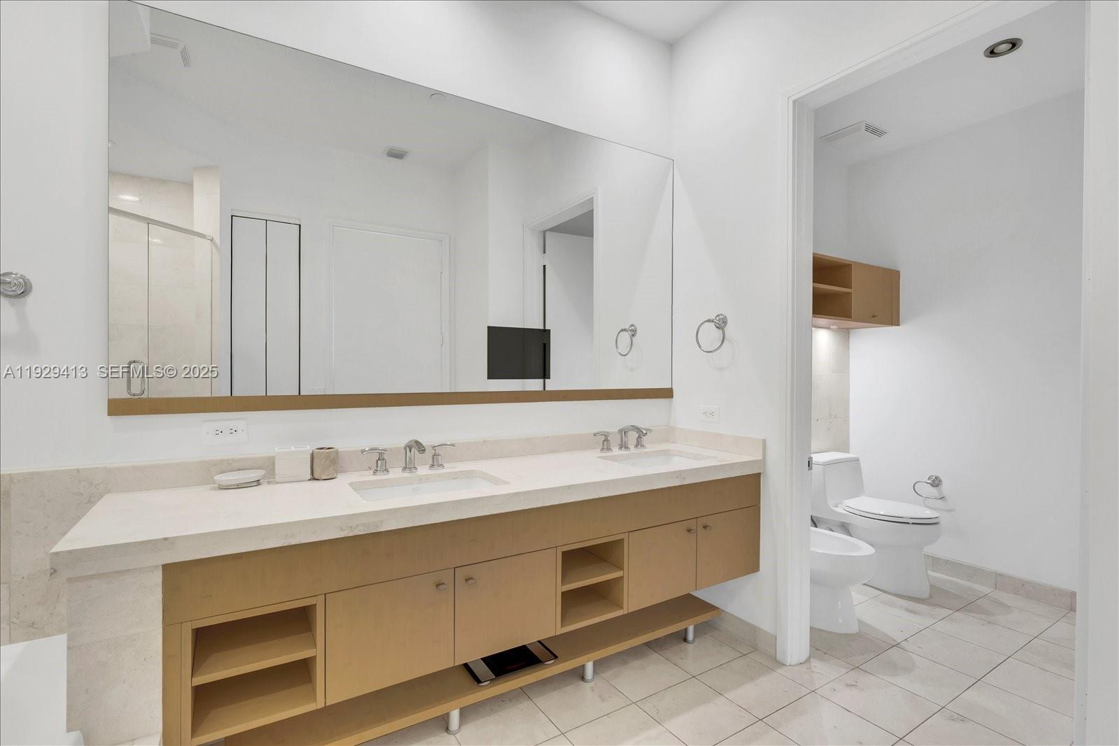 900 Brickell Key Boulevard, Unit 2605 Miami, FL 33131 - Photo 16 of 43 a bathroom with a toilet sink and mirror