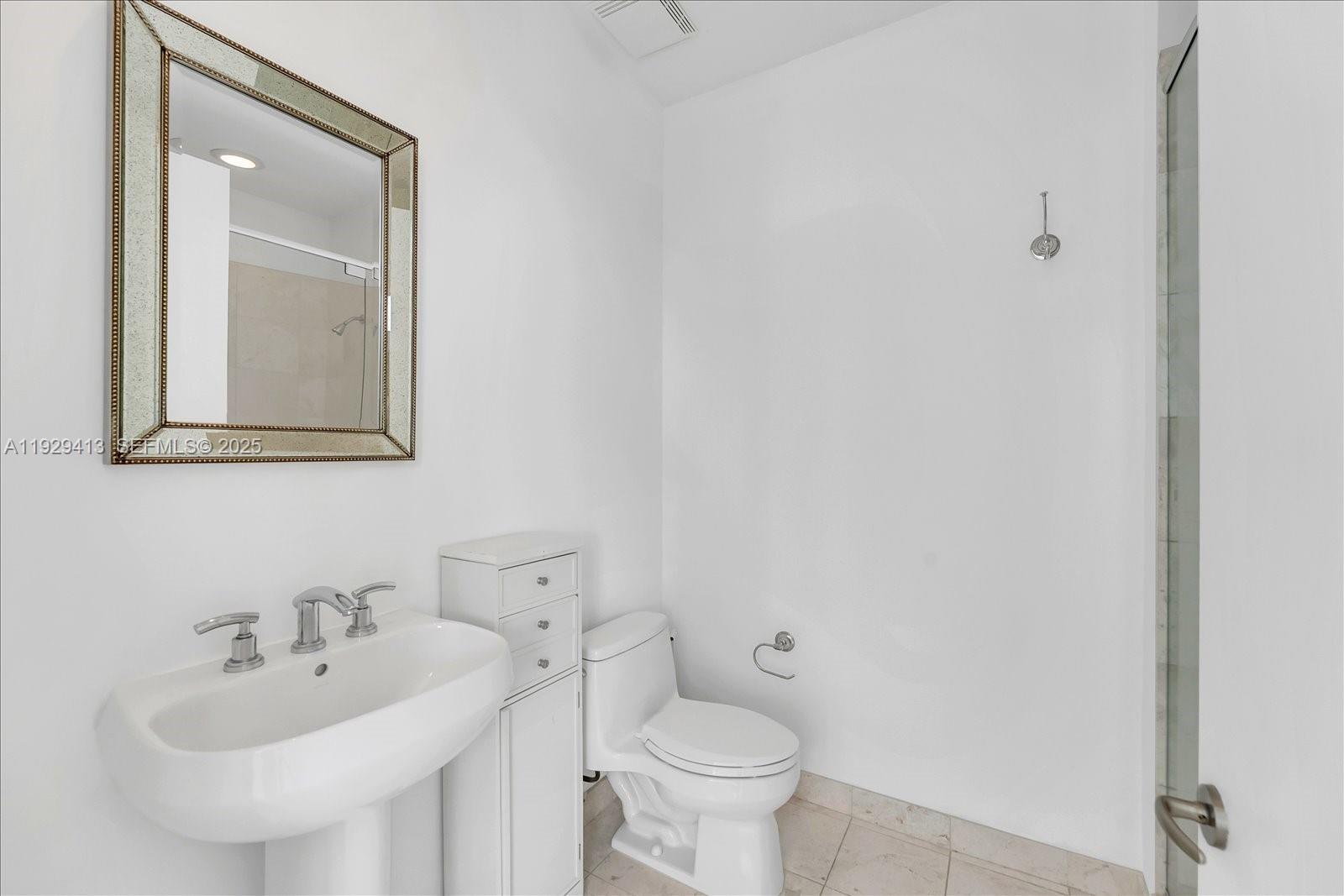 900 Brickell Key Boulevard, Unit 2605 Miami, FL 33131 - Photo 22 of 43 a bathroom with a toilet sink and mirror