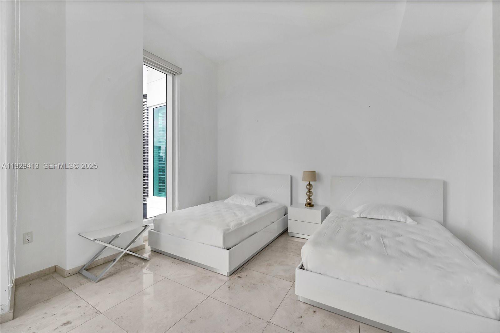 900 Brickell Key Boulevard, Unit 2605 Miami, FL 33131 - Photo 23 of 43 a bedroom with a bed and a window