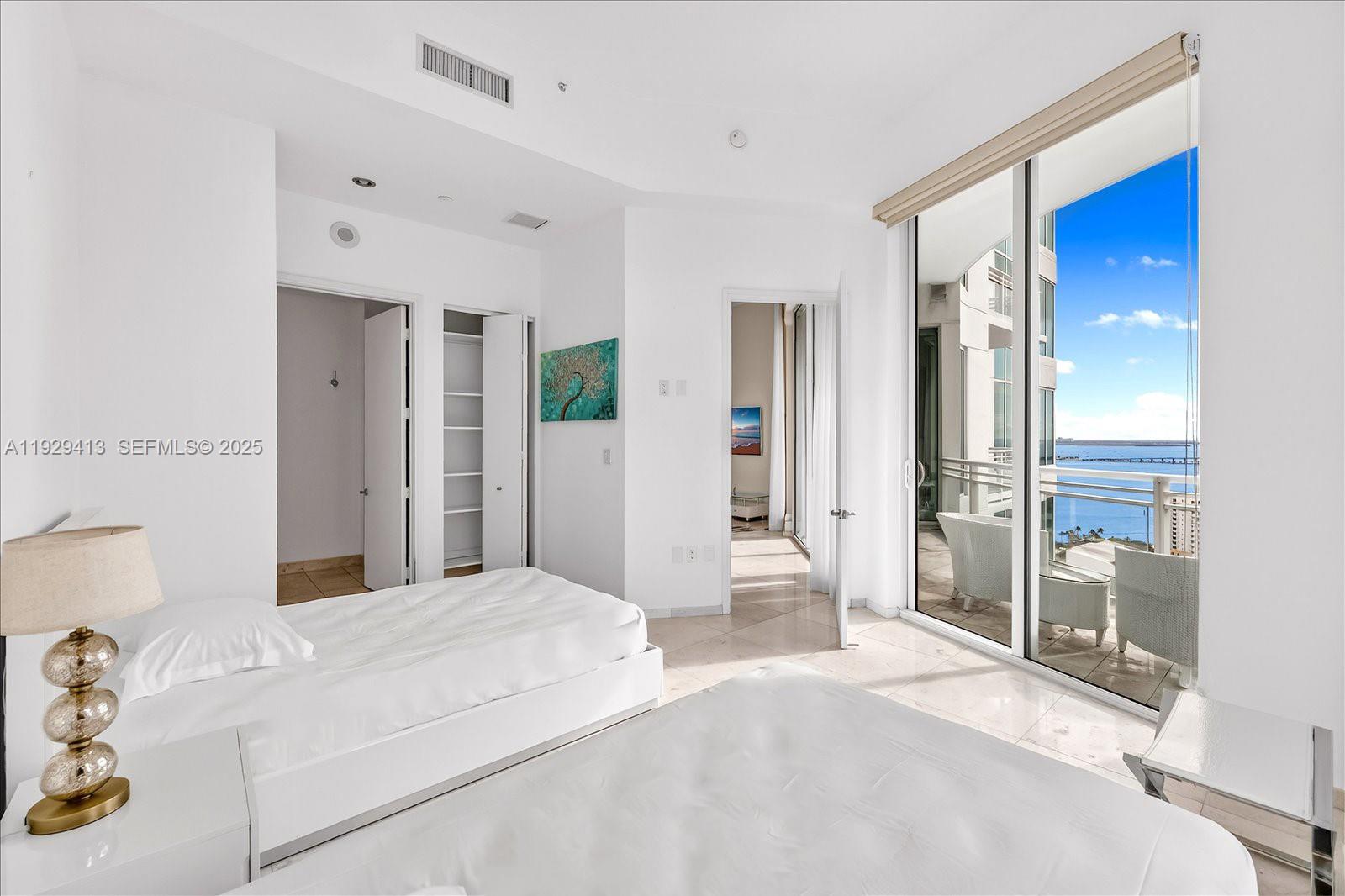 900 Brickell Key Boulevard, Unit 2605 Miami, FL 33131 - Photo 25 of 43 a bedroom with a bed and a large mirror