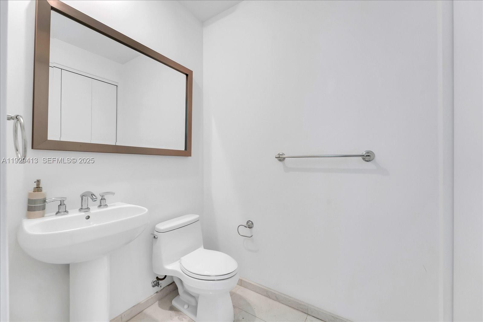 900 Brickell Key Boulevard, Unit 2605 Miami, FL 33131 - Photo 27 of 43 a bathroom with a toilet sink and mirror