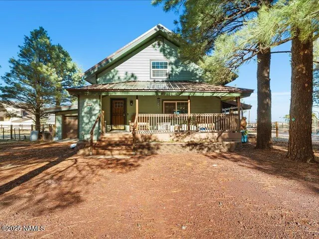 a view of a white house with a yard and sitting area