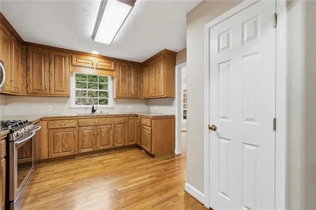 a bathroom with a granite countertop toilet a sink and a mirror