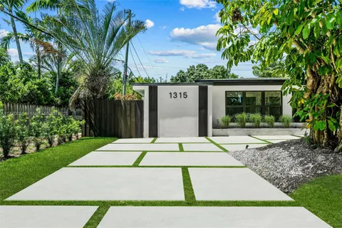 a view of a white house with a small garden