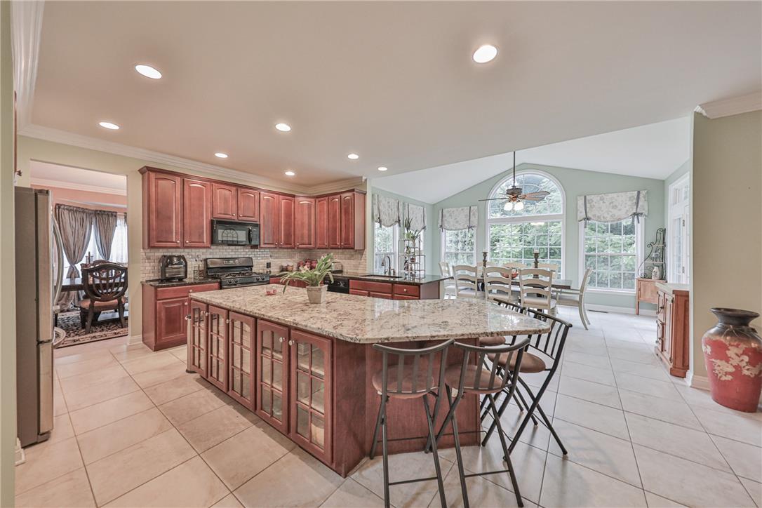 138 Clover Hollow Road Easton, PA 18045 - Photo 20 of 95 An inviting kitchen with rich cabinetry and an expansive island flows seamlessly into a naturally illuminated dining area.