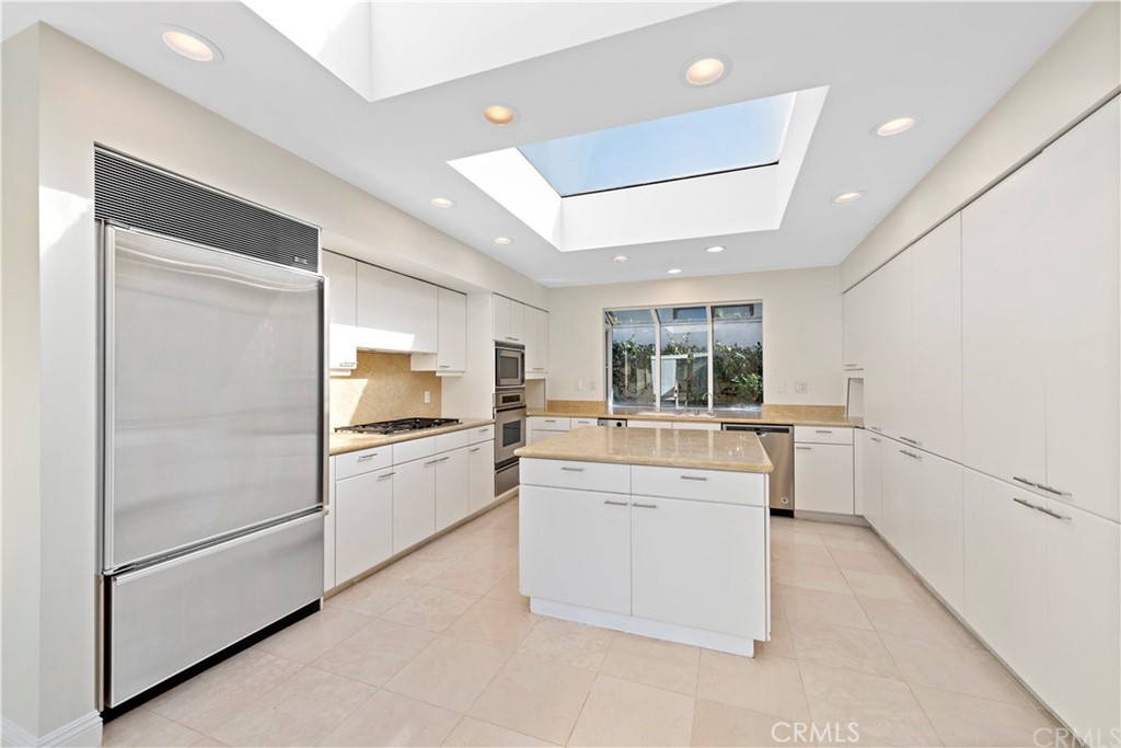 147 Monarch Bay Drive Dana Point, CA 92629 - Photo 8 of 23 a kitchen with a refrigerator and white cabinets