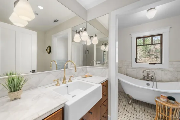 a bathroom with a tub sink and mirror