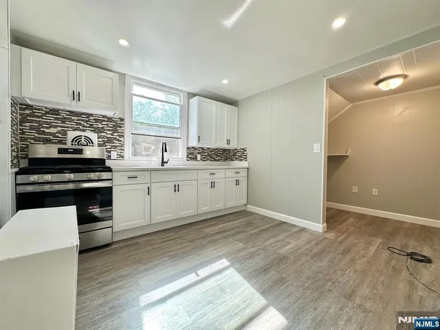 a kitchen with a sink a stove and cabinets