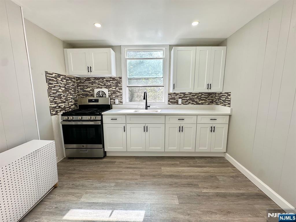 23 Trimble Avenue, Unit 2 Clifton, NJ 07011 - Photo 14 of 16 a kitchen with stainless steel appliances granite countertop a stove a sink and a refrigerator
