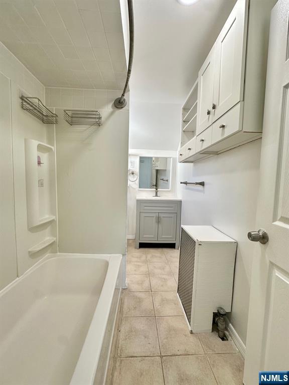 23 Trimble Avenue, Unit 2 Clifton, NJ 07011 - Photo 9 of 16 a bathroom with a tub sink and mirror