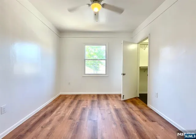 an empty room with wooden floor and window