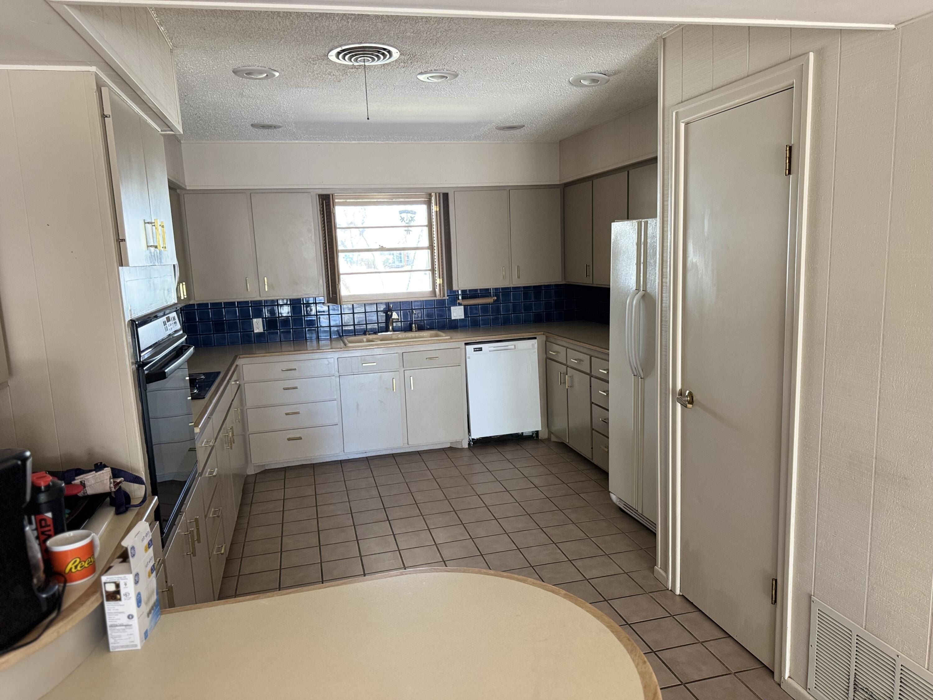 2115 62nd Street Lubbock, TX 79412 - Photo 8 of 15 a kitchen with a sink a refrigerator and cabinets