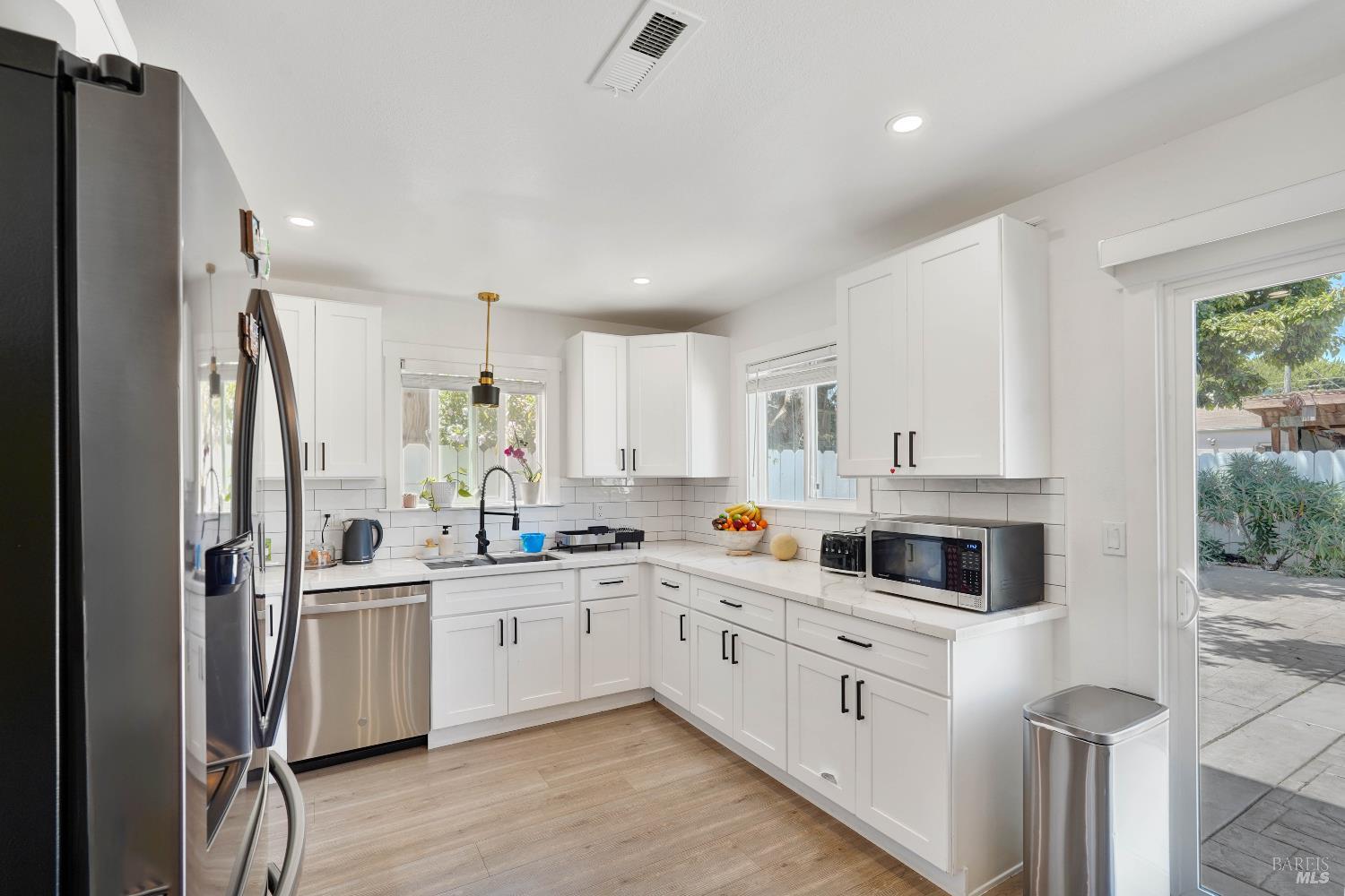 451 37th Street Richmond, CA 94805 - Photo 11 of 36 a kitchen with white cabinets and white appliances