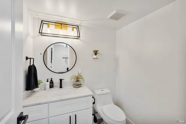 a bathroom with a toilet a sink and a mirror