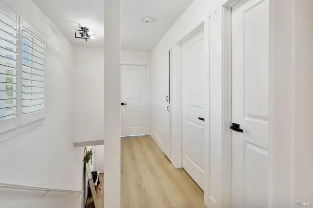 a view of a hallway with wooden floor and entryway