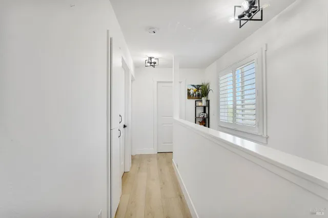 a view of a hallway with wooden floor and a window